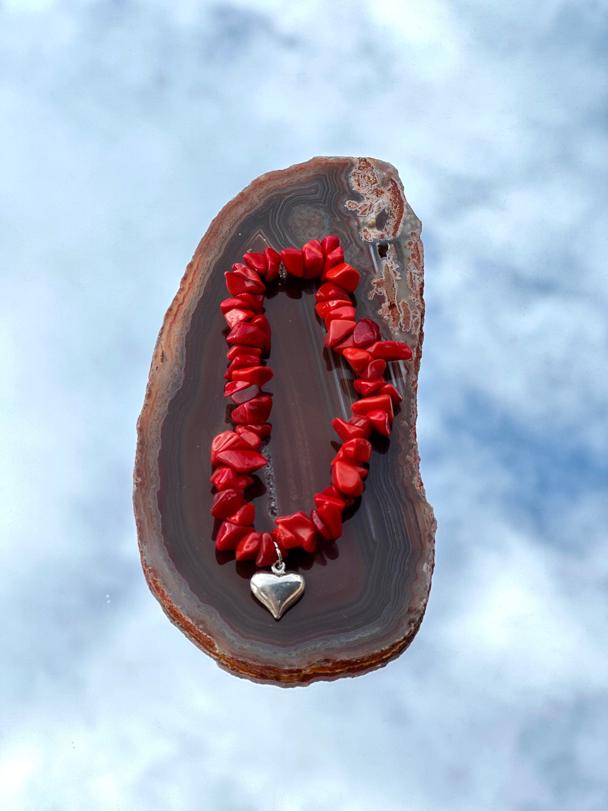 Kärleksfullt skydd: Heart bracelet med röd opak och en silverfärgad hjärtberlock. Stärker känslor, sänker garden och lugnar nerverna. Inspirerar hängivenhet och trohet. Harmoniserar med alla chakran och kopplad till Kräftan, Vågen, Skorpionen och Fiskarna. Omfamna starka band och finn lugn. #HeartBracelet #Opak #Kärlek #Stjärntecken #Chakra